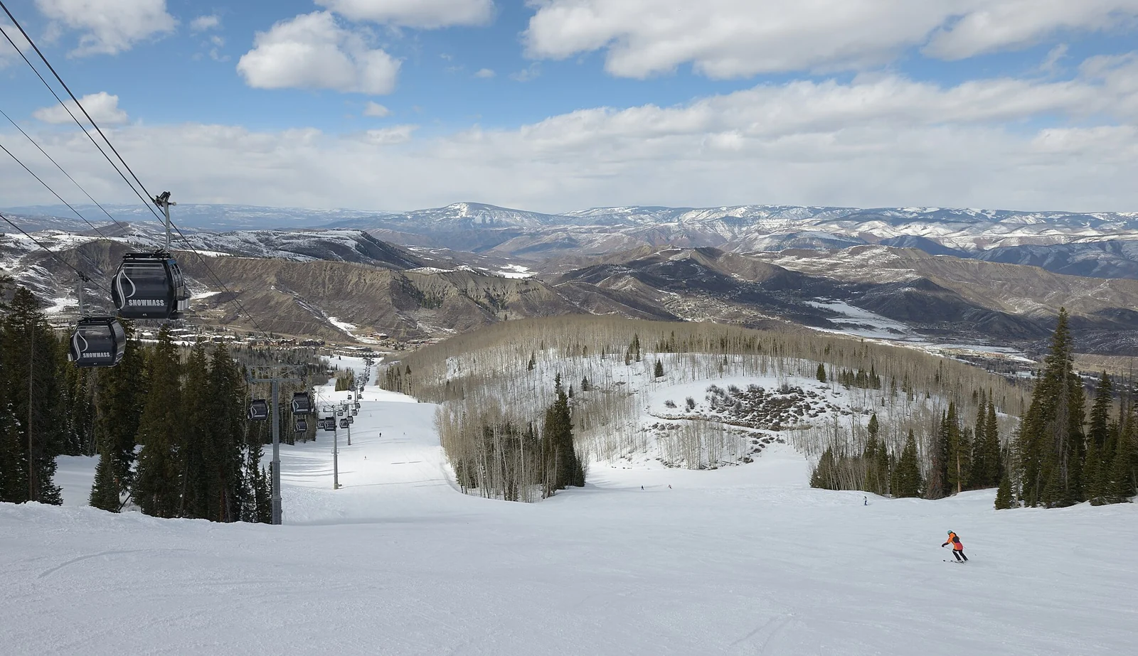 Gondola cabins and a snowy run in the Elk Camp sector at Snowmass, Colorado.
