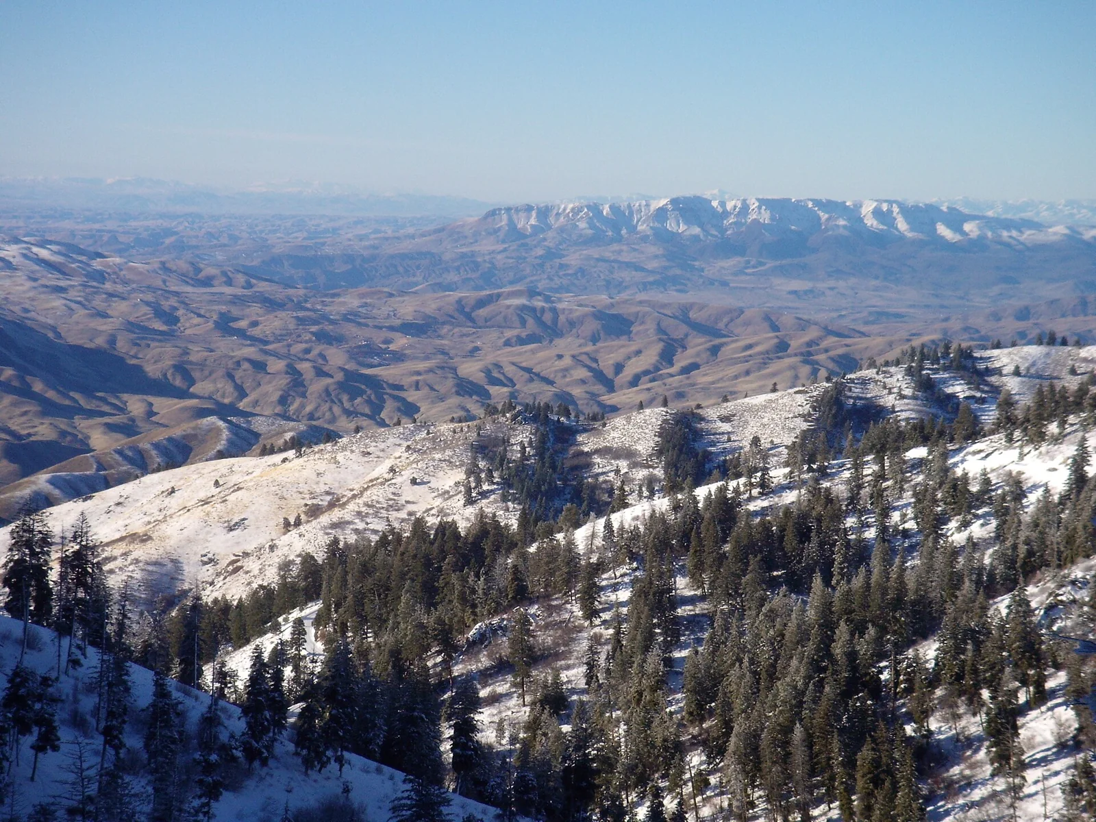 Snow-covered slopes and mountain valleys viewed from the back side of Bogus Basin, Idaho.