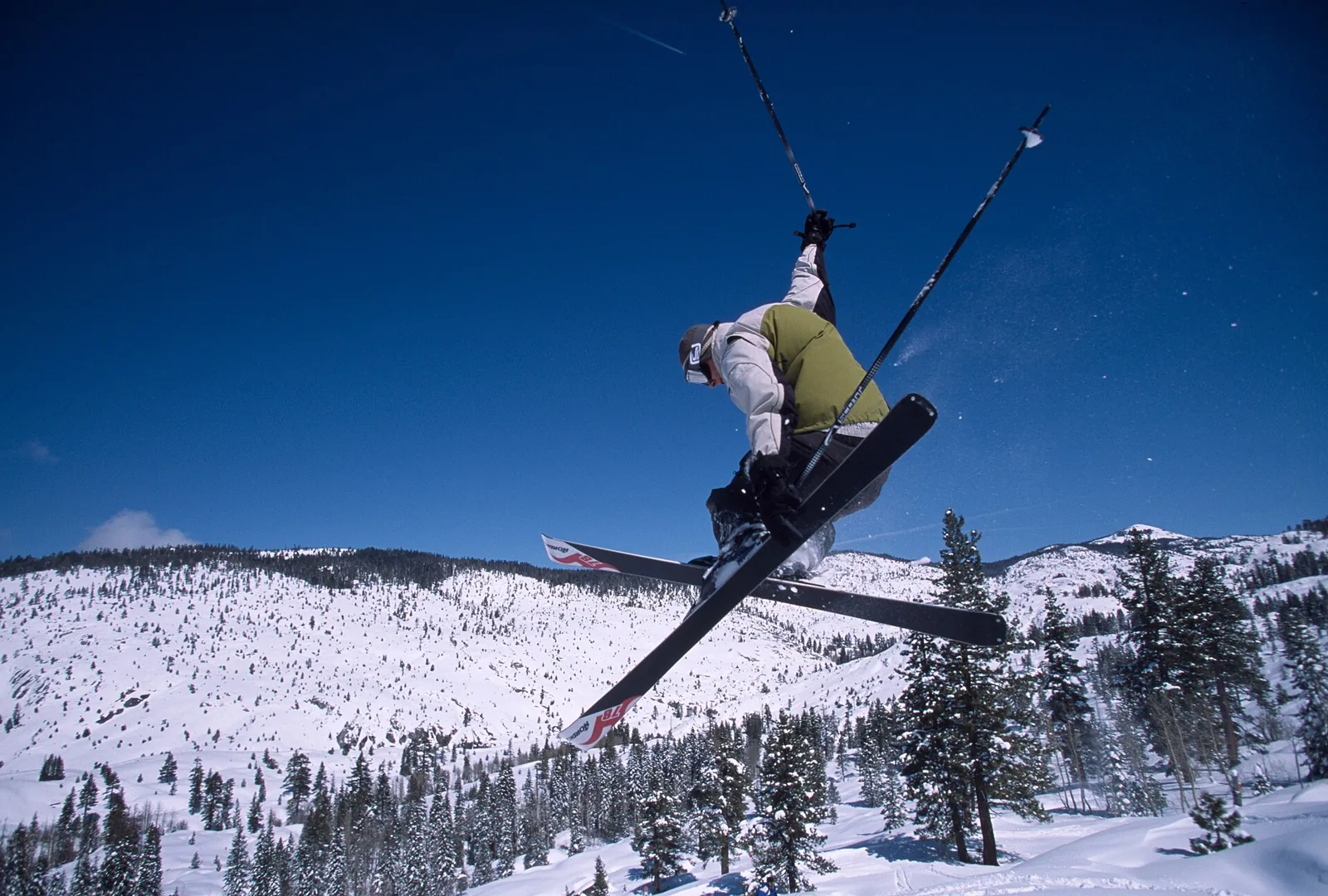 A skier in mid-air over snow at Dodge Ridge Wintersports Area, California.