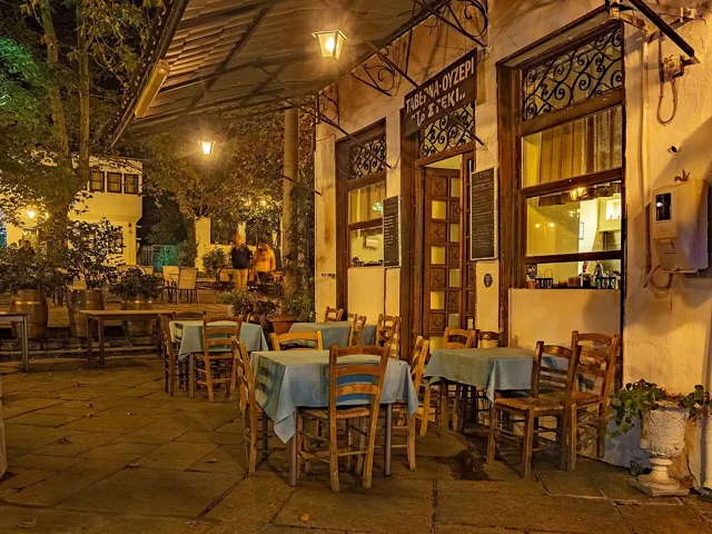 Tables and illuminated buildings in Portaria square