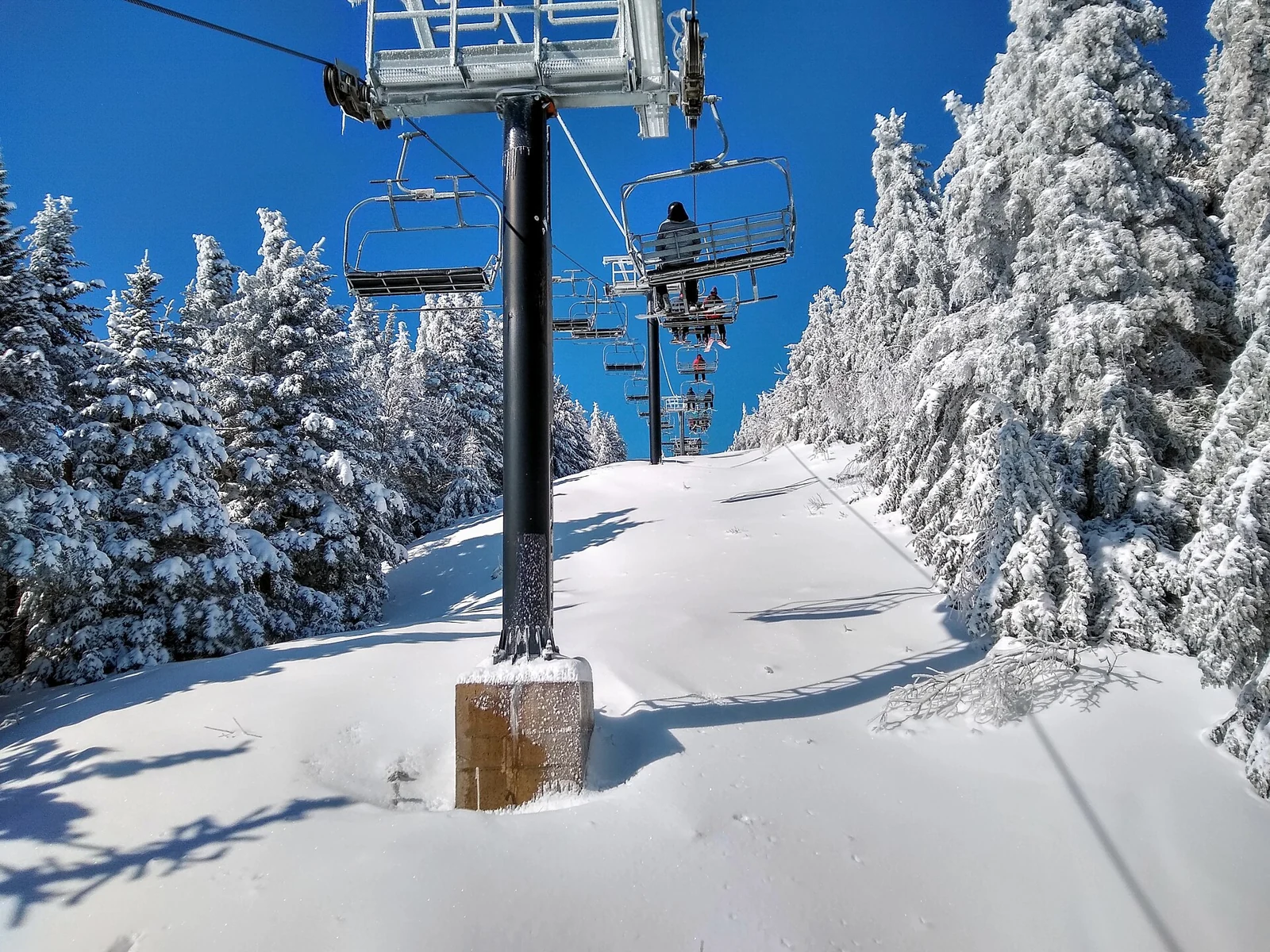 A chairlift between snow-covered trees at Gore Mountain, New York.