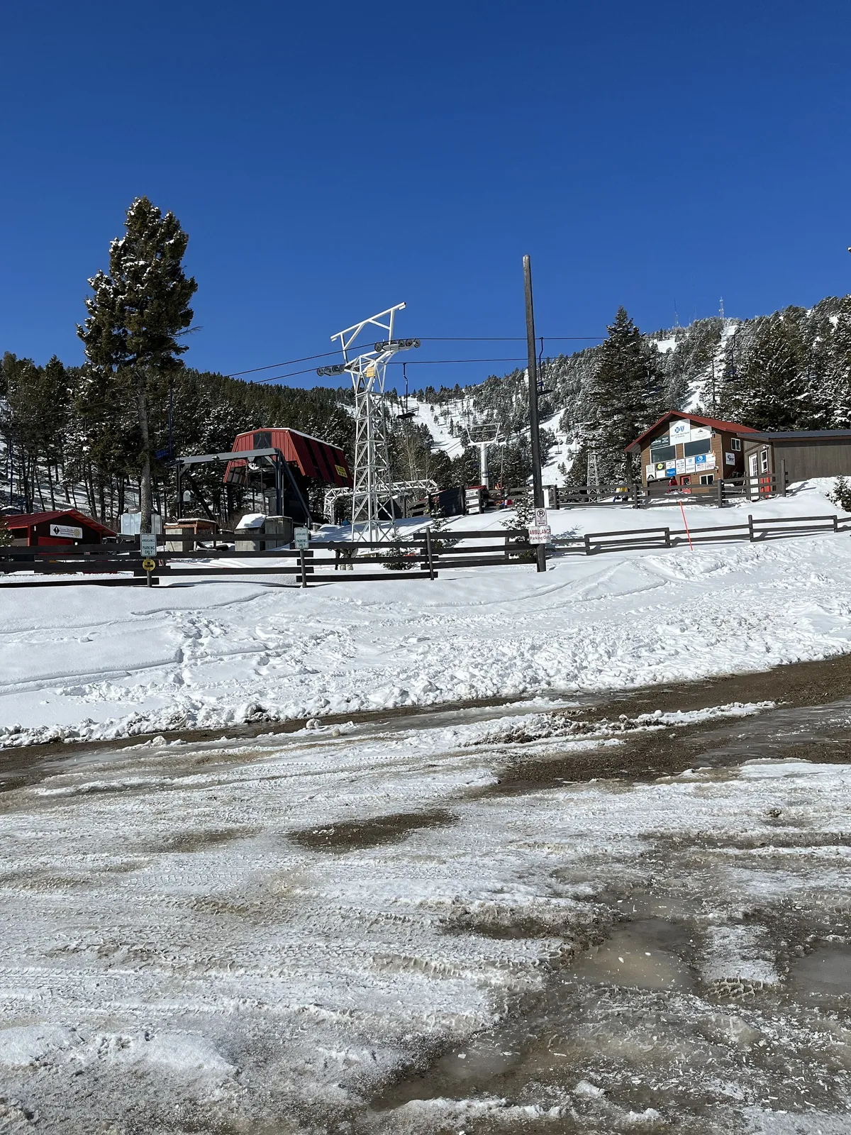 A chairlift and snow-covered base area at Great Divide, Montana.