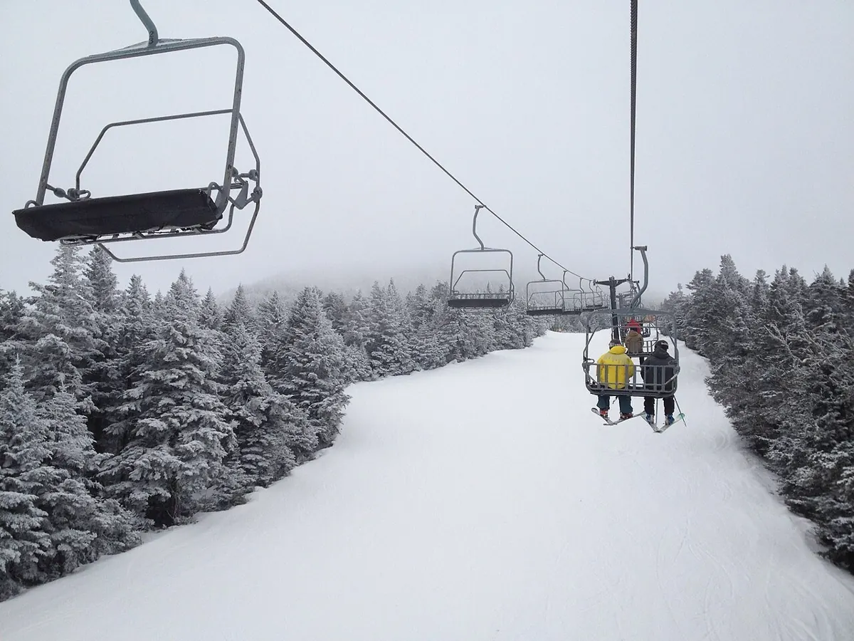 Skiers riding the ski lift up the slopes in Killington, Vermont during the winter.