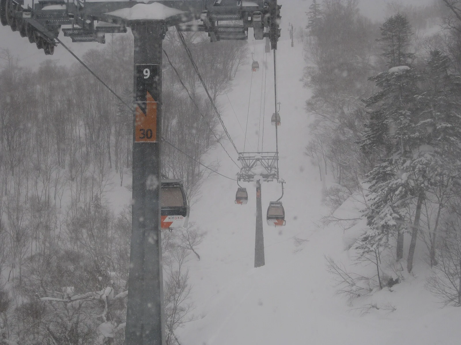 Gondola cabins travelling through heavy snowfall at Kiroro Snow World, Hokkaido.
