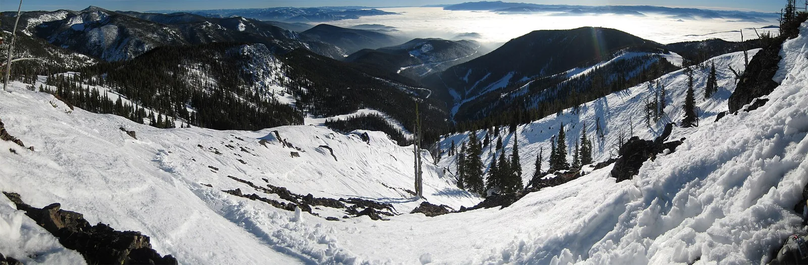A broad snowy bowl and conifer-covered ridges at Montana Snowbowl.