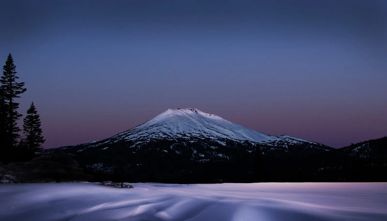 Mount Bachelor above snow-covered ground in early morning light, Oregon.