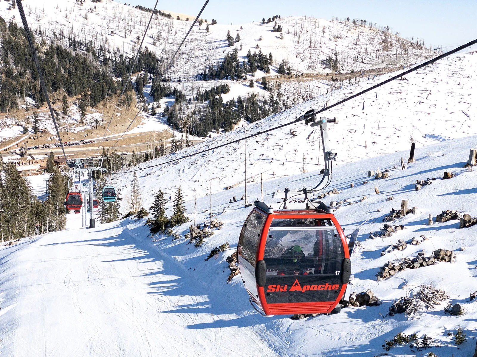 Gondola cabins travel over snowy terrain at Ski Apache, New Mexico.
