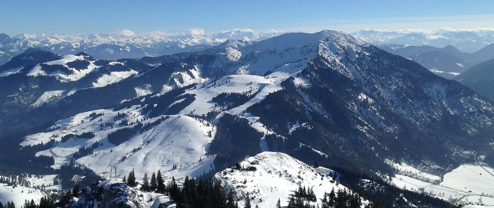 Panoramic view of the snowy Sudelfeld slopes and surrounding peaks.