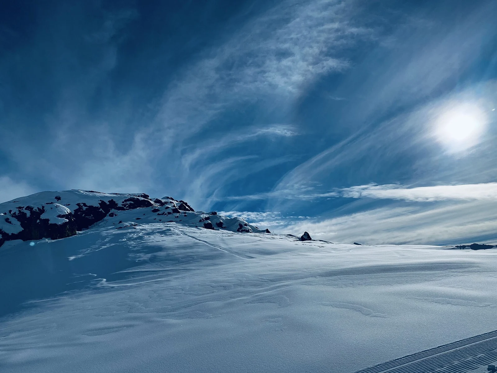 A snow-covered mountain slope beneath a blue sky at Sun Valley Resort, Idaho.